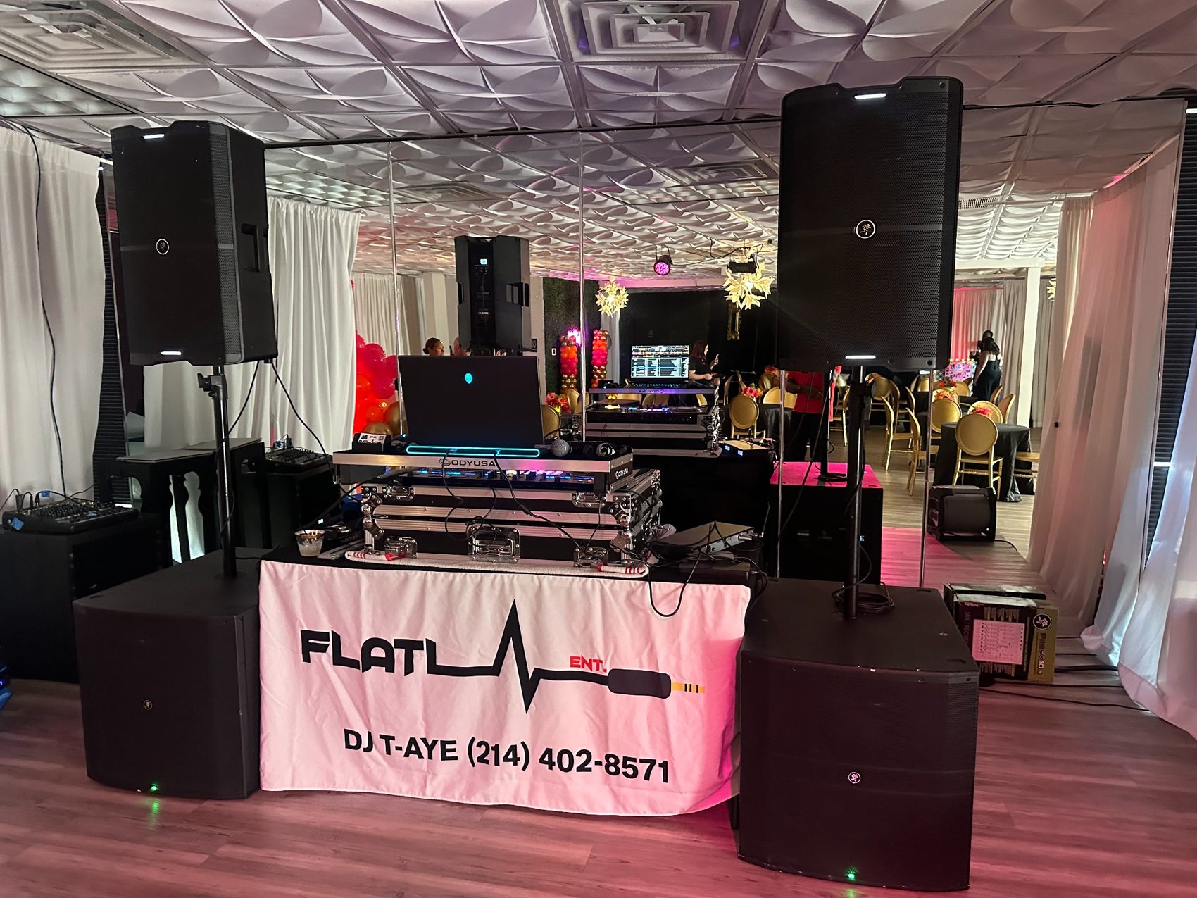Flatlyne Entertainment DJ setup with speakers and branded table cover